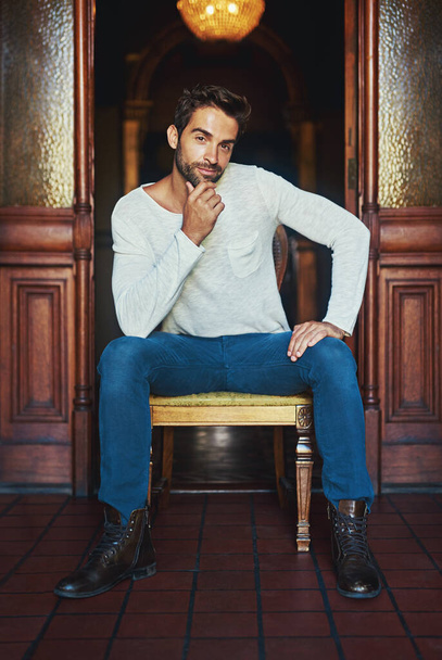 Id say these jeans do me justice. Portrait of a handsome man dressed in casual wear posing on a chair - Foto, imagen
