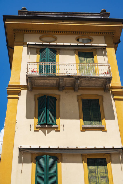 The bright yellow exterior of the historic 19th-century lakefront Hotel Olivedo in Varenna against the blue sky. Lombardy, Italy. - Foto, immagini