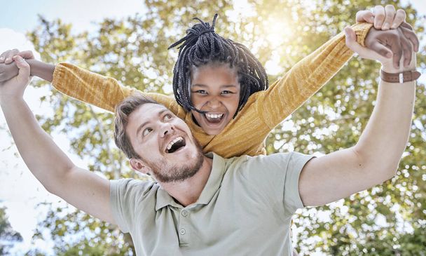 Family, child and adoption piggy back with happy, excited and fun father bonding with daughter in nature. Happiness, care and support of foster dad with black kid smile together in park - Foto, afbeelding