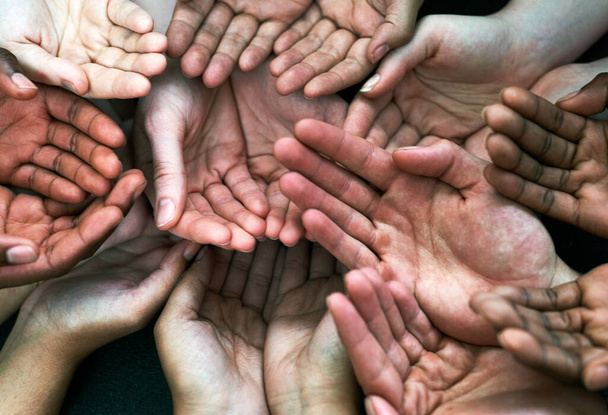 We seek your assistance. a group of hands held cupped out together - Foto, Imagen