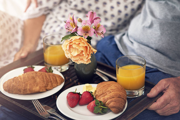 Лечите свою жену завтраком в постели. пожилая пара завтракает в постели - Фото, изображение