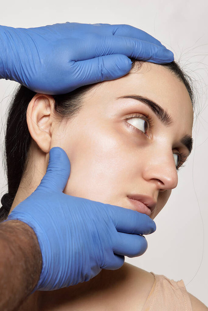 un viso e le mani delle donne con guanti blu, come lei sta ricevendo il suo trattamento di botanica - Foto, immagini