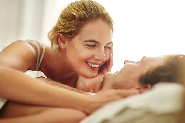 Good morning, handsome. an affectionate young couple relaxing in bed at home - Foto, afbeelding
