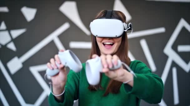 Молода зацікавлена жінка грає в VR-ігри з використанням VR окулярів і контролерів. Повільний рух
 - Кадри, відео