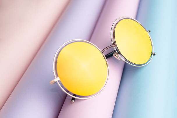 Móda slunečních brýlí se žlutou čočkou dát na barevné papírové pozadí - Fotografie, Obrázek