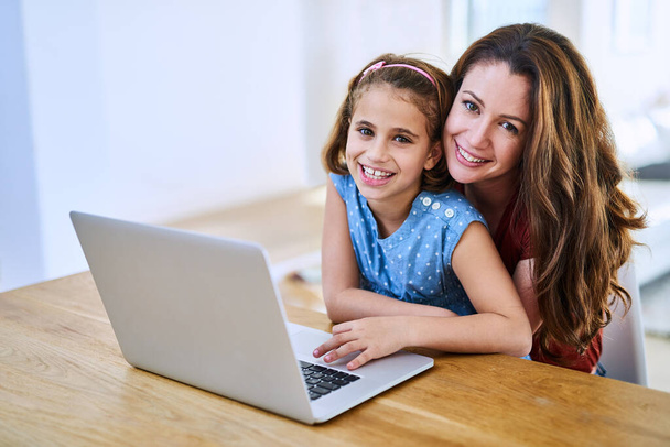 Explorando juntos la tecnología. Retrato de una madre y una hija usando un portátil juntas en casa - Foto, imagen