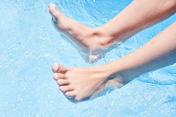 certains pieds dans l'eau avec leurs orteils qui sortent et ils sont debout sur le bord de la piscine - Photo, image