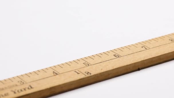 Close up of wooden yard stick with scales in inches and one yard fractions on white background. - Footage, Video