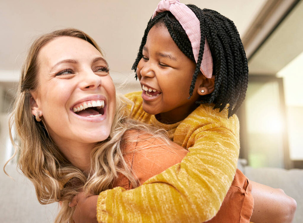 Piggyback, bonding and mother and child in foster care on mothers day with love, smile and support. Family, interracial and African girl with a playful hug for her mom after adoption in their home. - Foto, Imagen