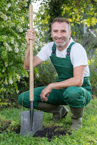 man with a shovel in the garden - Фото, изображение