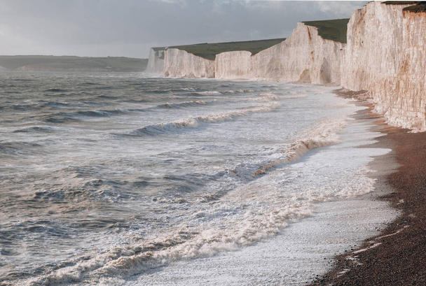 Olas golpeando la playa por los acantilados de tiza de Seven Sisters, uno de los tramos más largos de costa subdesarrollada en la costa sur, East Sussex, Reino Unido. - Foto, Imagen