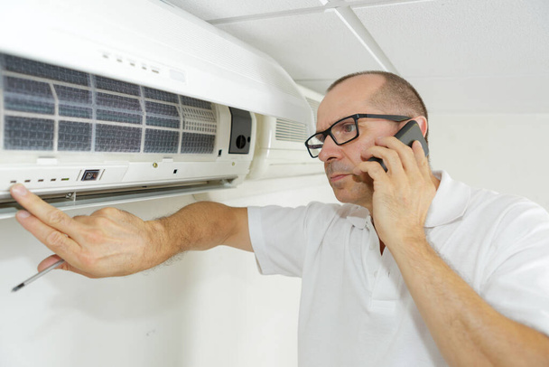 a split type airconditioning technician - Foto, Bild