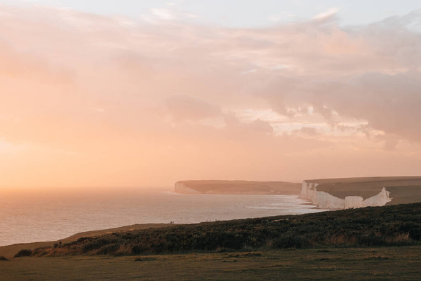 Golden hour pastel coloured sky over the Seven Sisters křídové útesy, jeden z nejdelších úseků nevyvinutého pobřeží na jižním pobřeží, East Sussex, Velká Británie. - Fotografie, Obrázek