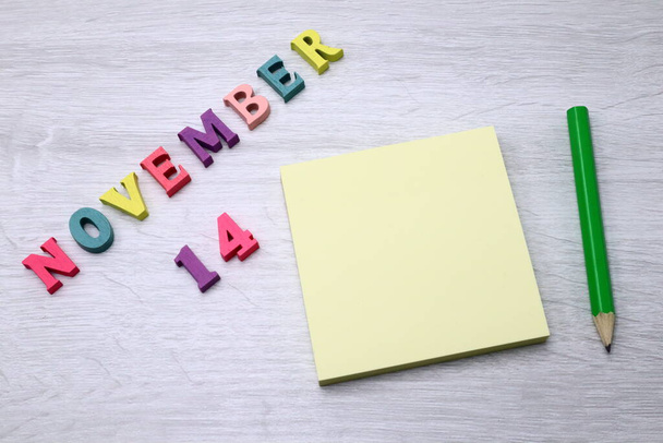 November 14   - Daily colorful Calendar with Block Notes and Pencil on wood table background, empty space for your text or design - Foto, Imagem