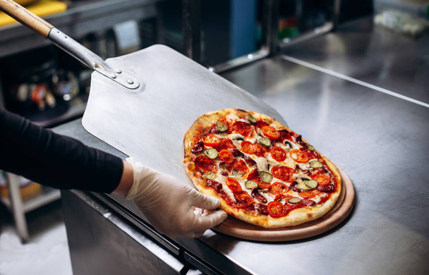 Крупный план размещения пиццы в духовке в пиццерии - Фото, изображение