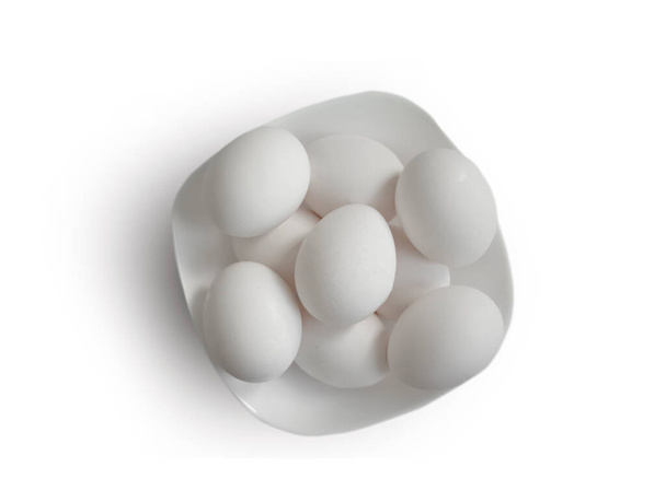 Huevos enteros en un plato aislado sobre fondo blanco - Foto, Imagen