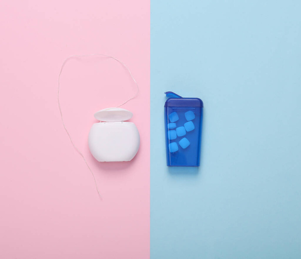 Scatola di gomma da masticare per alito fresco e filo interdentale su sfondo pastello blu-rosa. Vista dall'alto - Foto, immagini
