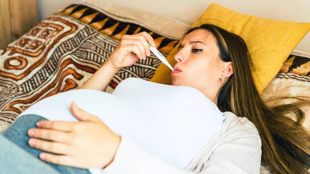 Control de temperatura del termómetro embarazada. Embarazo mujer sosteniendo termómetro, comprobar la fiebre temperatura de la gripe. Niña embarazada enferma. Concepto de embarazo, maternidad, expectativa de parto - Foto, Imagen