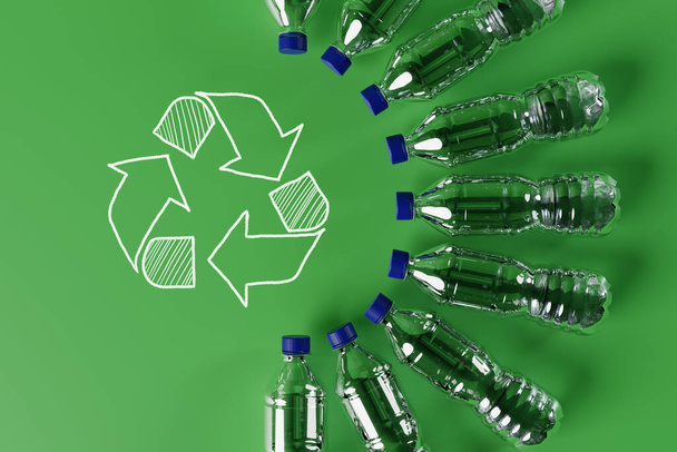 Botellas de plástico con el icono de reciclaje y flechas de reciclaje pintadas. Concepto de naturaleza y protección del medio ambiente. Reciclaje plástico. 3d renderizar - Foto, imagen