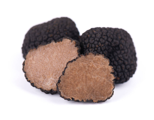 Black truffles isolated on a white background. Fresh sliced truffle. Delicacy exclusive truffle mushroom. Piquant and fragrant French delicacy. Clipping path - 写真・画像