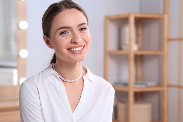 Young woman wearing elegant pearl necklace indoors, space for text - Foto, Bild