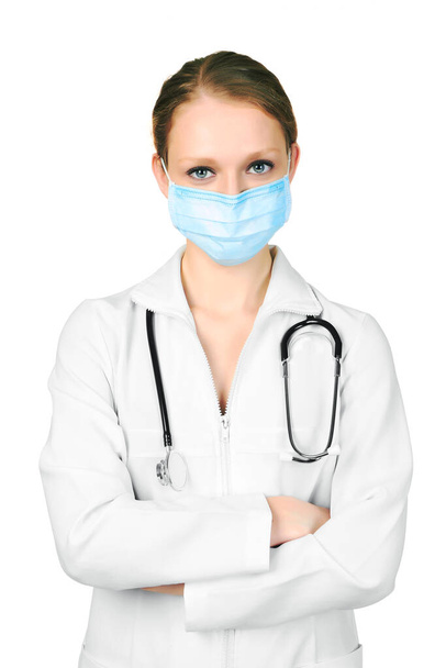 Vrouwelijke arts in een masker met stethoscoop, geïsoleerd op witte achtergrond - Foto, afbeelding