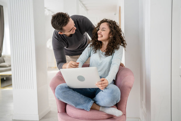 Kadın ve erkek çiftler sınav sonuçlarını kontrol eder ya da birlikte çalışırlar evde dizüstü bilgisayar kullanarak mutlu bir gülümseme alanı kopyalarlar parlak odada internetten gerçek insanları seçerler. - Fotoğraf, Görsel