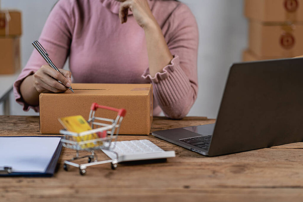 Entrepreneur d'affaires de PME travaillant de la maison avec des boîtes de colis et ordinateur portable prenant des commandes et expédiant des idées d'affaires d'épicerie en ligne - Photo, image