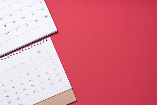 close up of calendar on the red table background, planning for business meeting or travel planning concept - Fotó, kép