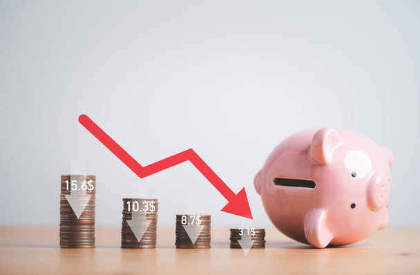 Rückgang der Münzen stapeln und Pfeil nach unten mit gefallenen rosa Sparschwein für Wirtschaftskrise und Financial Business Konkurs Konzept. - Foto, Bild