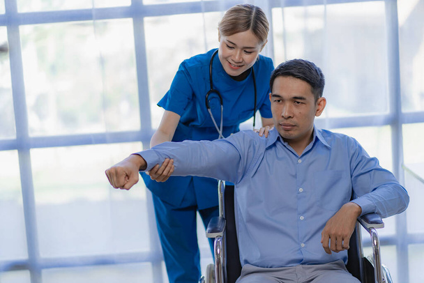 Asiatique femme médecin faire physiothérapie pour les hommes patient avec poignet et épaule douleur - Photo, image