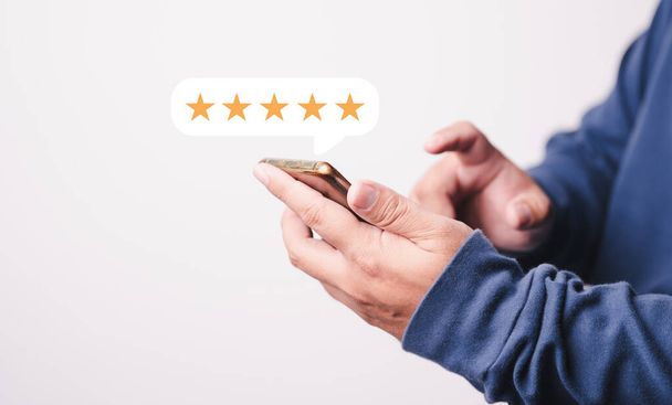 Customer Man hand press σε οθόνη smartphone με χρυσές κριτικές πέντε αστέρων και εξαιρετικό επίπεδο τύπου για την καλύτερη βαθμολογία στην κριτική. - Φωτογραφία, εικόνα