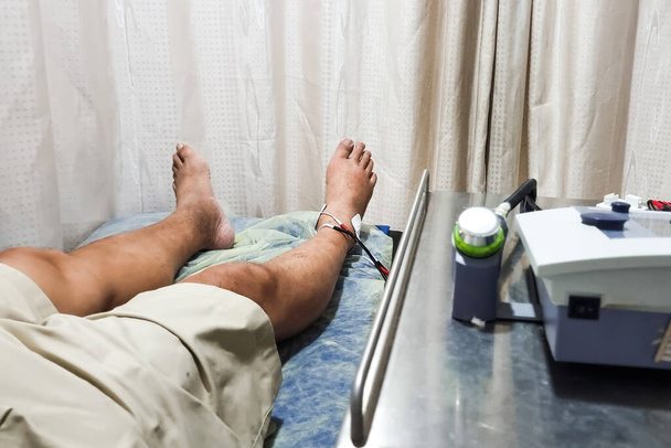 Paciente recebendo terapia interferencial como parte do curso de fisioterapia para curar o pé do tornozelo lesionado no hospital - Foto, Imagem