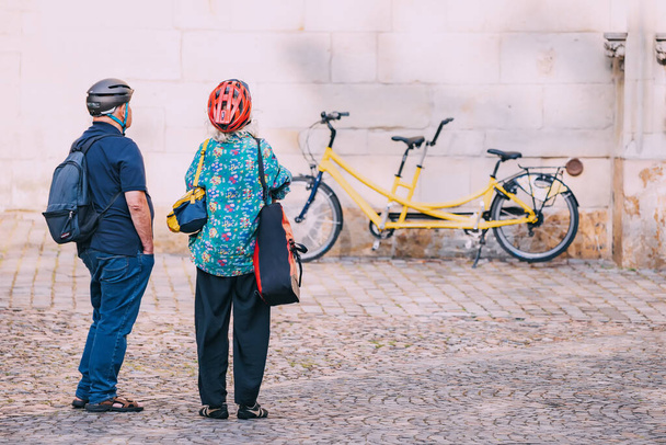 25 lipca 2022, Munster, Niemcy: Starsza para przyjechała na tandemowym rowerze i zwiedziła stare miasto - Zdjęcie, obraz