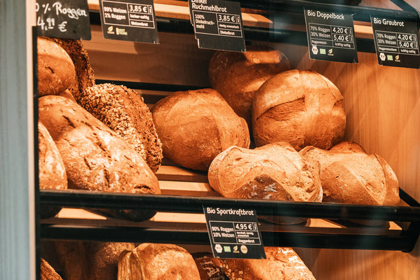 26 July 2022, Munster, Germany: bakery products, delicious and fresh wheat bread and buns on the shop counter - Foto, Imagen