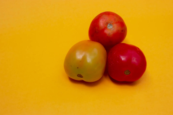 три помідори ізольовані на жовтому
 - Фото, зображення