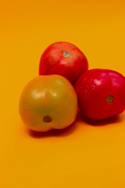 trzy pomidory izolowane na żółto - Zdjęcie, obraz