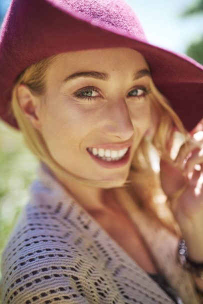 Jasné úsměvy za jasného slunečného dne. Portrét atraktivní mladé ženy ve slunečním klobouku stojící venku - Fotografie, Obrázek