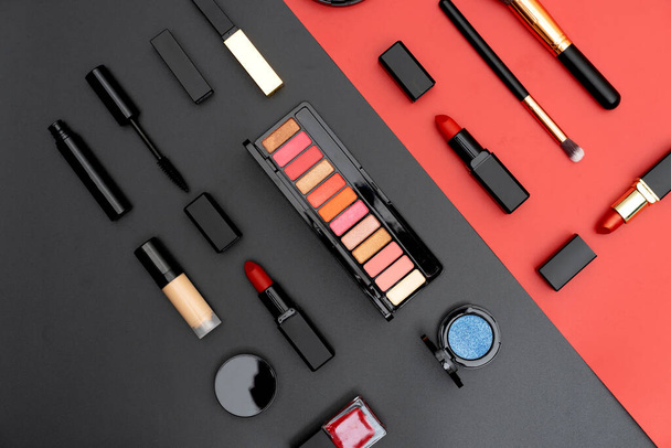 set decorative cosmetics on black and red background - Foto, Imagen