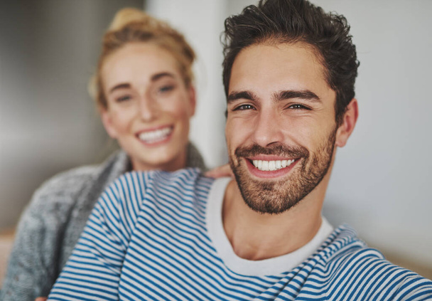 Nothing but happiness on this home front. Portrait of a happy young couple relaxing on their sofa at home - Foto, afbeelding