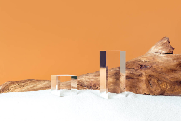 Mockup stage for advertising made with transparent acrylic cubes and weathered snag on a sandy background with copy space. Luxury pedestal for cosmetic product presentation or package advertisement. - Zdjęcie, obraz