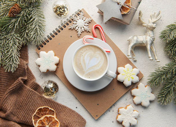 A cup of coffee latte, homemade cookies and Christmas balls and knitted sweater. Winter holidays concept. Top view, flat lay - Фото, изображение