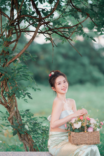Dziewczyna w tradycyjnej chińskiej sukience jest w ogrodzie - Zdjęcie, obraz