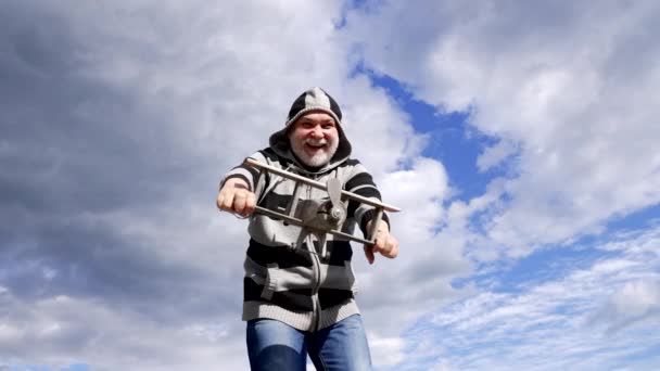 Gelukkige oude man doen alsof vliegen op houten vliegtuig torenhoog, vlucht. - Video
