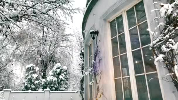 Το σπίτι μετά από μια χιονόπτωση κατά τους χειμερινούς μήνες. Υπάρχει ένα παχύ στρώμα χιονιού που καλύπτει τα δέντρα. Μετά από μια ελαφριά χιονόπτωση, η φύση περιβάλλει το σπίτι σε όλη του τη δόξα - Πλάνα, βίντεο