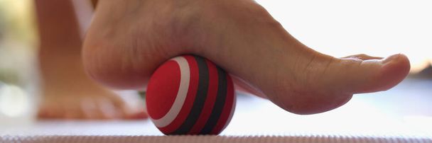 Person rolls massage ball with foot of foot closeup. Useful exercises for feet concept - Photo, Image