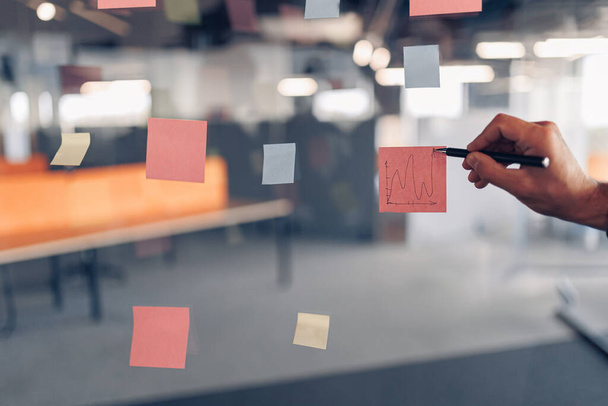 Businessman hands is writing on sticky notes on board in office. High quality photo - Fotografie, Obrázek
