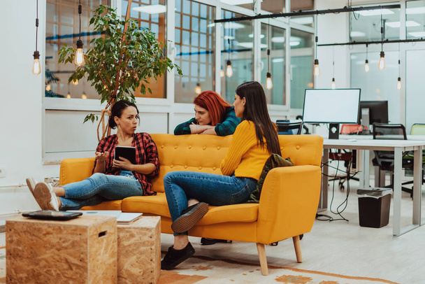 group of female friends having a team meeting and discussion about project or gossip chatting in modern startup business office. High quality photo - Photo, image