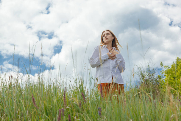 hermosa chica en camisa blanca y falda naranja contra el cielo azul y las nubes de cerca - Foto, Imagen