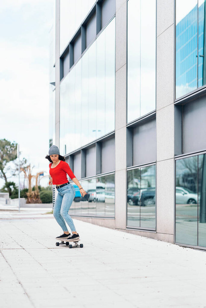 Cool skater woman practicing with her longboard in the city and having fun. - Fotó, kép